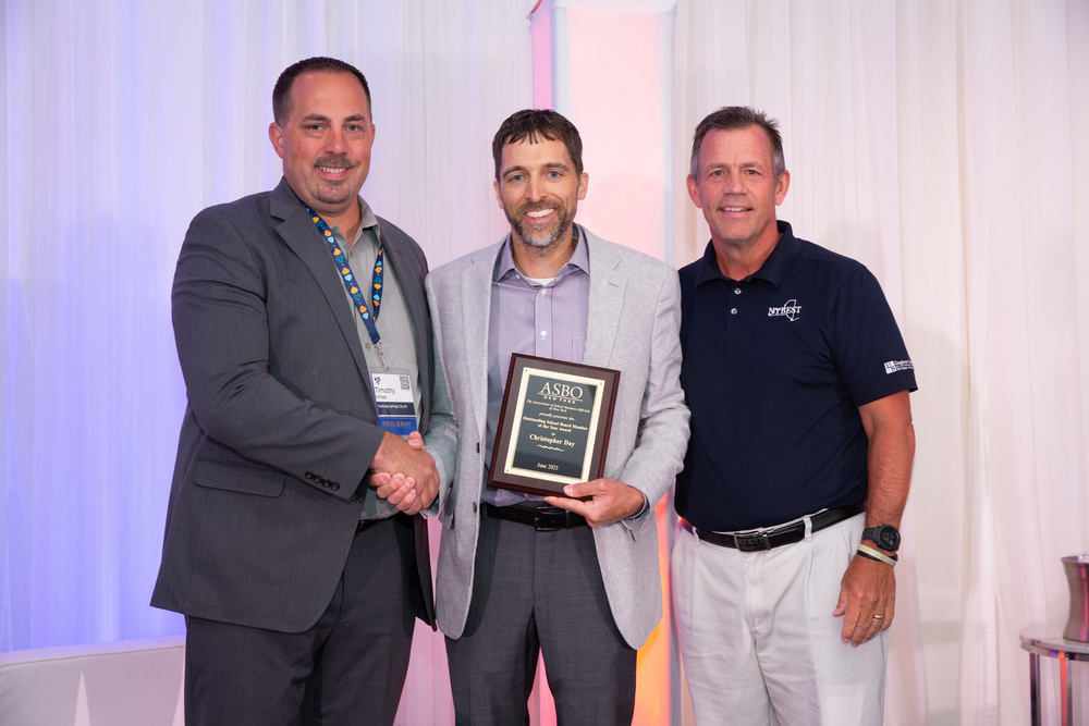 Attica Board of Education President Christopher Day, center, accepts the 2023 Outstanding School Board Member of the Year Award from the New York State Association of School Business Officials during its summer conference in Saratoga Springs in July. 