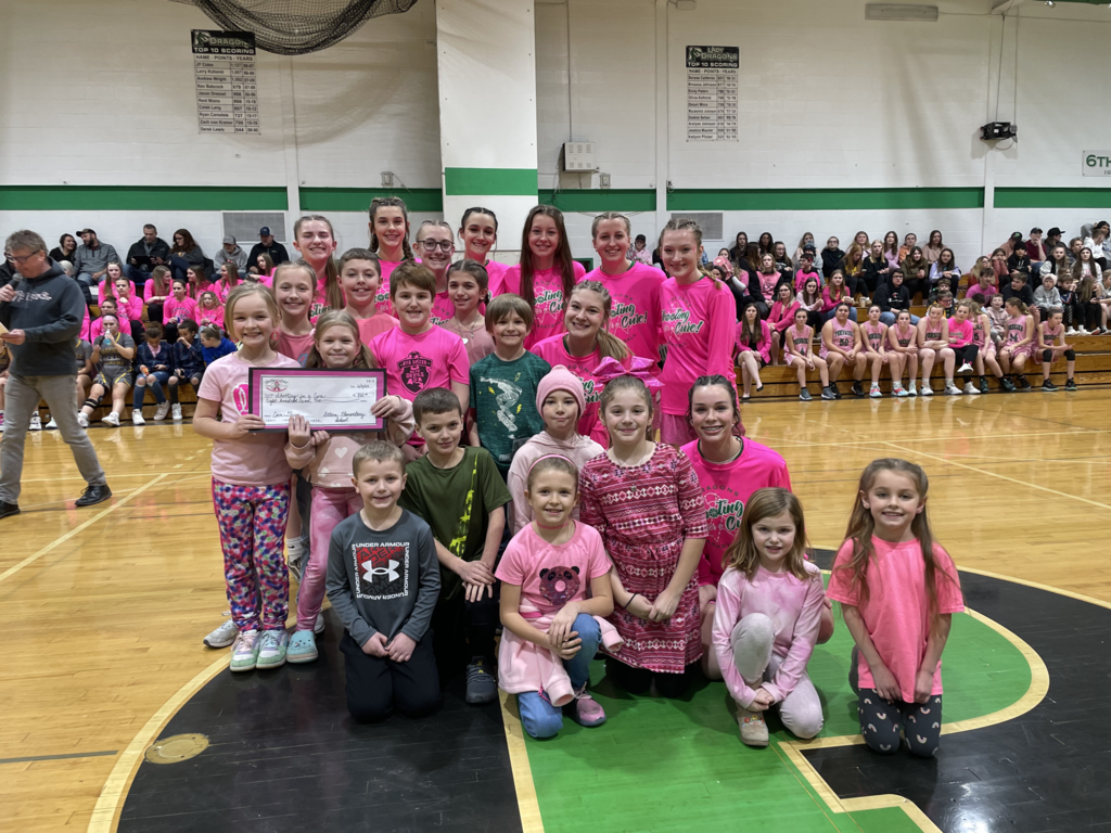 Attica Elementary School students pose for a photo with members of Pembroke’s varsity girls basketball team Friday at their Shoot for a Cure charity basketball game. Attica students donated $800 at the game. 