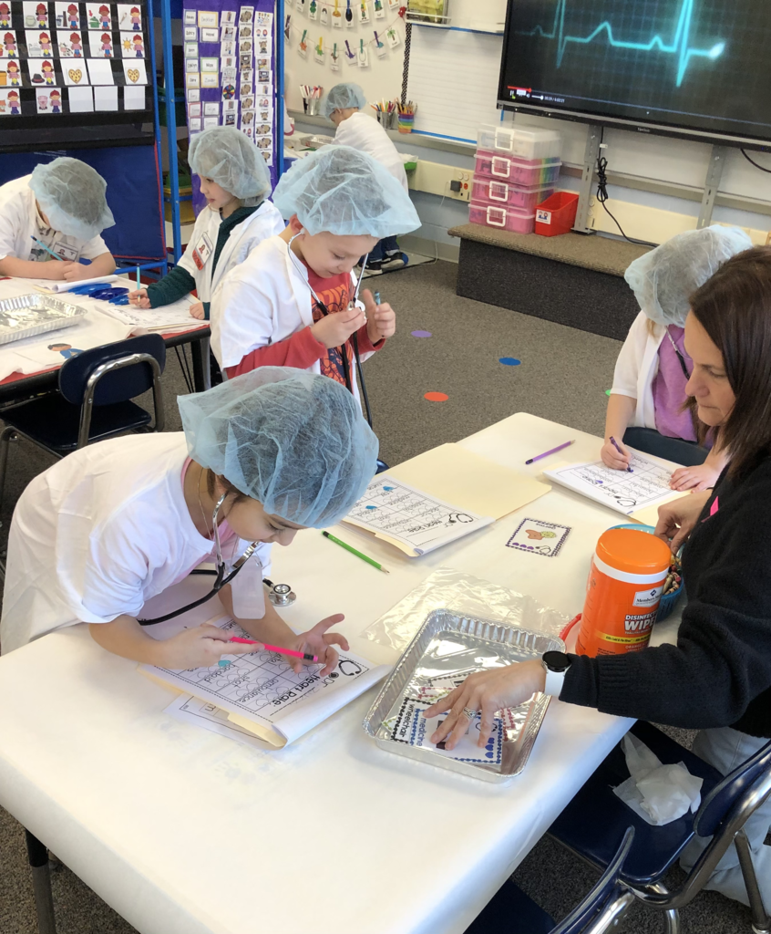 Students in Mrs. Kristin Janes’ kindergarten class are pictured performing “surgery” on ailing words during a recent reading lesson. 