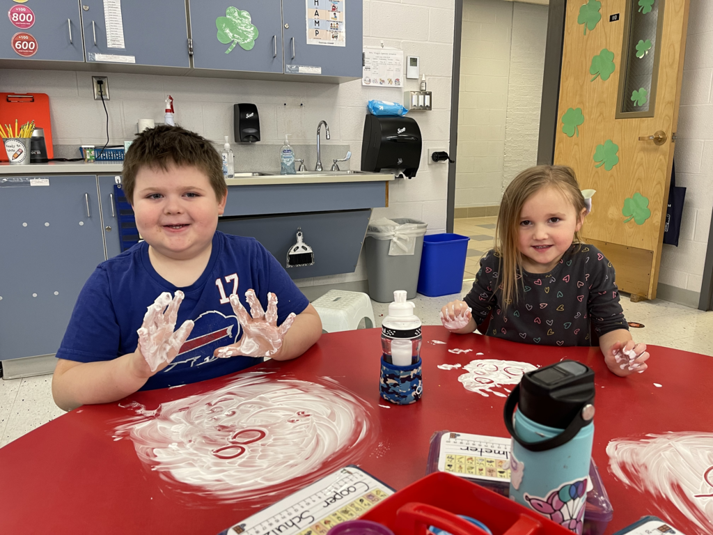 Mrs. Amanda Vilagy’s kindergarten students are pictured practicing their addition skills with shaving cream.