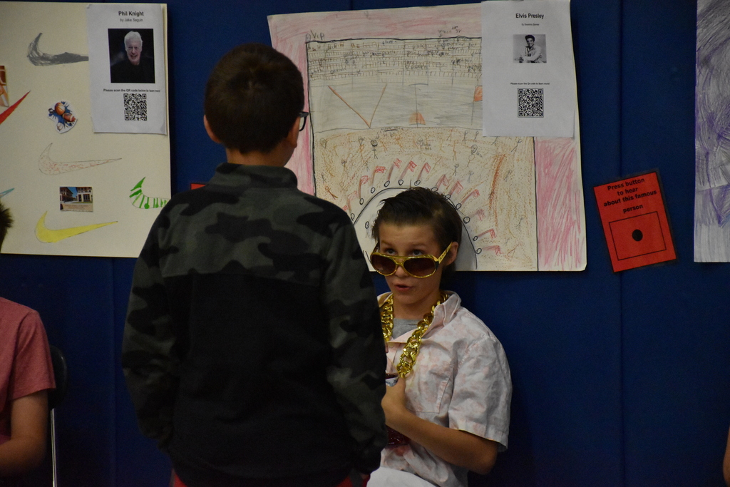 Sixth graders are shown presenting their biography research products during their Wax Museum in the Middle School Gymnasium.